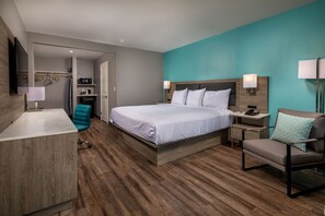 A modern hotel room with a large bed, a desk, a chair, and a TV. - Travelodge by Wyndham LAX (El Segundo)