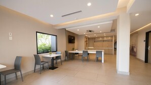 Un interior moderno con comedor, cocina y un gran ventanal con vistas a zonas verdes.
