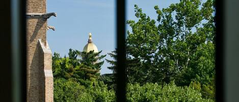 A view through a window with a brick structure and a dome in the background.