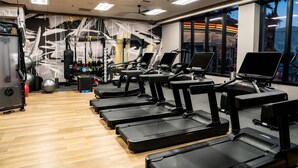 Ein Fitnessstudio mit Laufbändern, Trainingsbällen und Krafttrainingsgeräten.