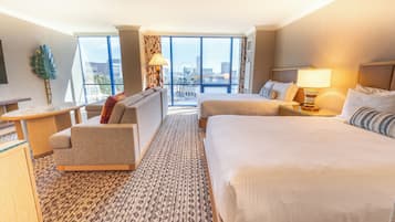 Habitación de hotel con una cama grande, un sofá, un escritorio y vistas a la ciudad.