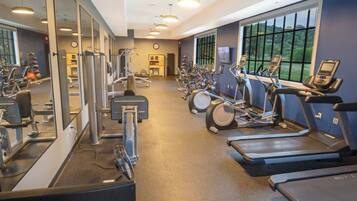 A gym with treadmills, elliptical machines, and weight equipment.
