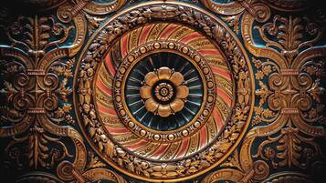 A detailed, ornate ceiling with a central circular design surrounded by intricate patterns and gold accents.