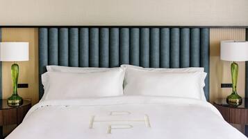 A hotel room with a bed, two bedside tables with lamps, and a headboard.