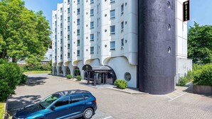 A modern hotel building with a unique architectural design, featuring a large cylindrical structure and multiple windows. - B&B HOTEL Bochum Hbf-Süd (Bochum)