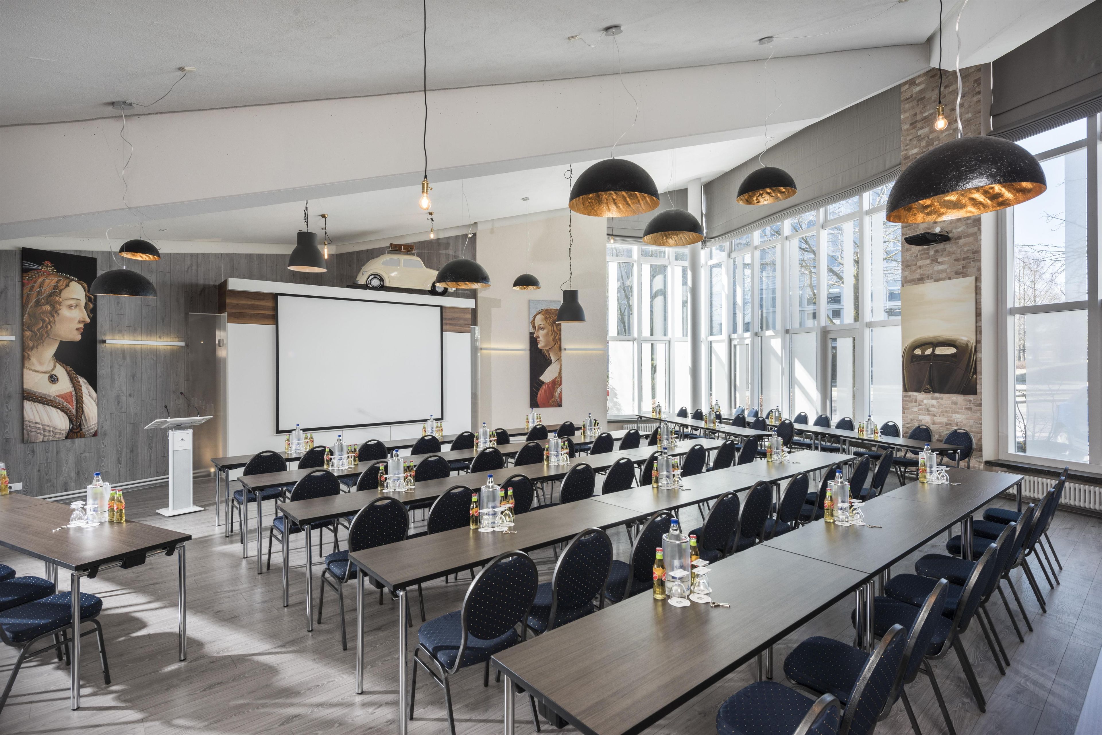 A conference room with long tables, chairs, and overhead lighting.