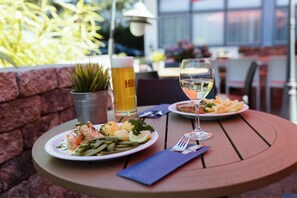 A table with a meal, a glass of white wine, and a beer mug. - Best Western Hotel Ambassador (Baunatal)