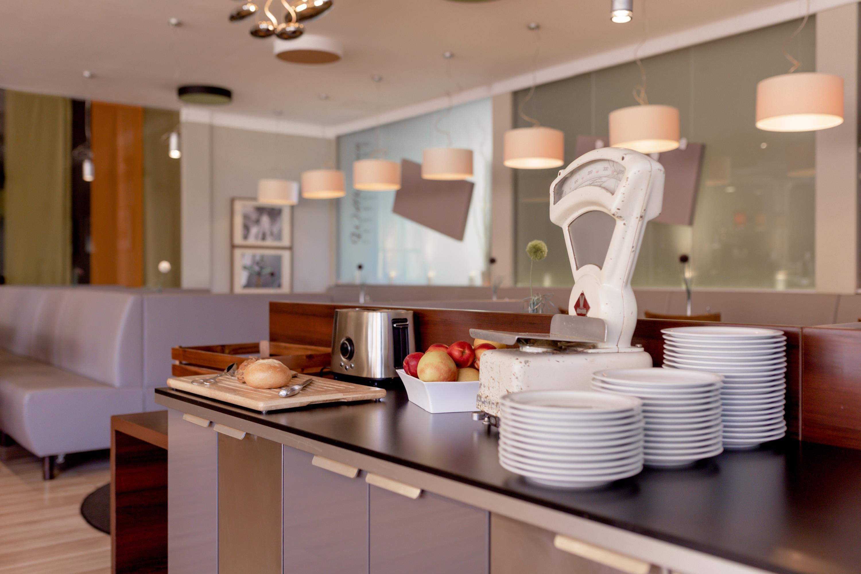 Una cocina moderna con una isla integrada, electrodomésticos de acero inoxidable y una zona de estar con sofá.