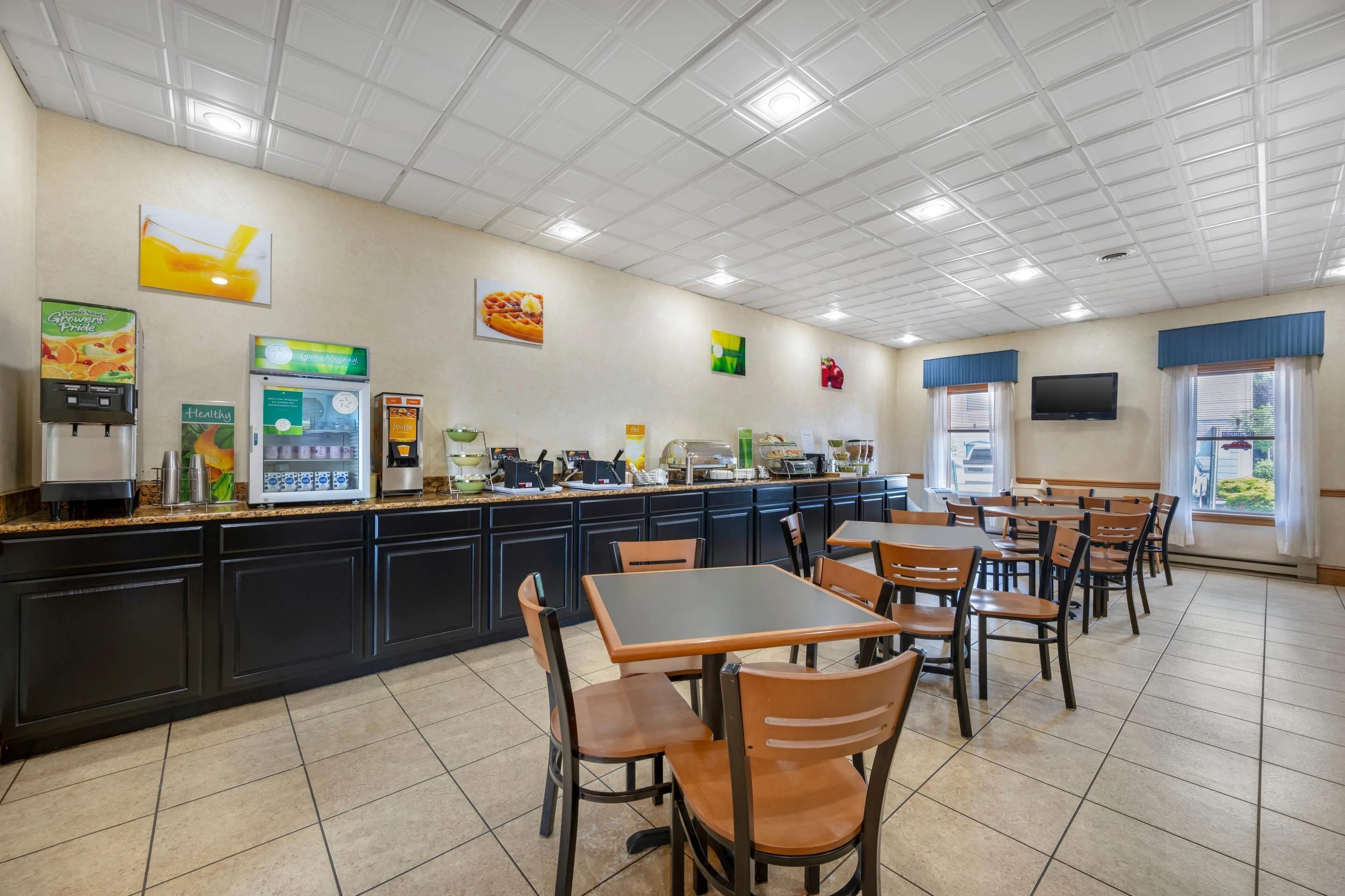 A cafeteria with a counter, seating, and various food service equipment.