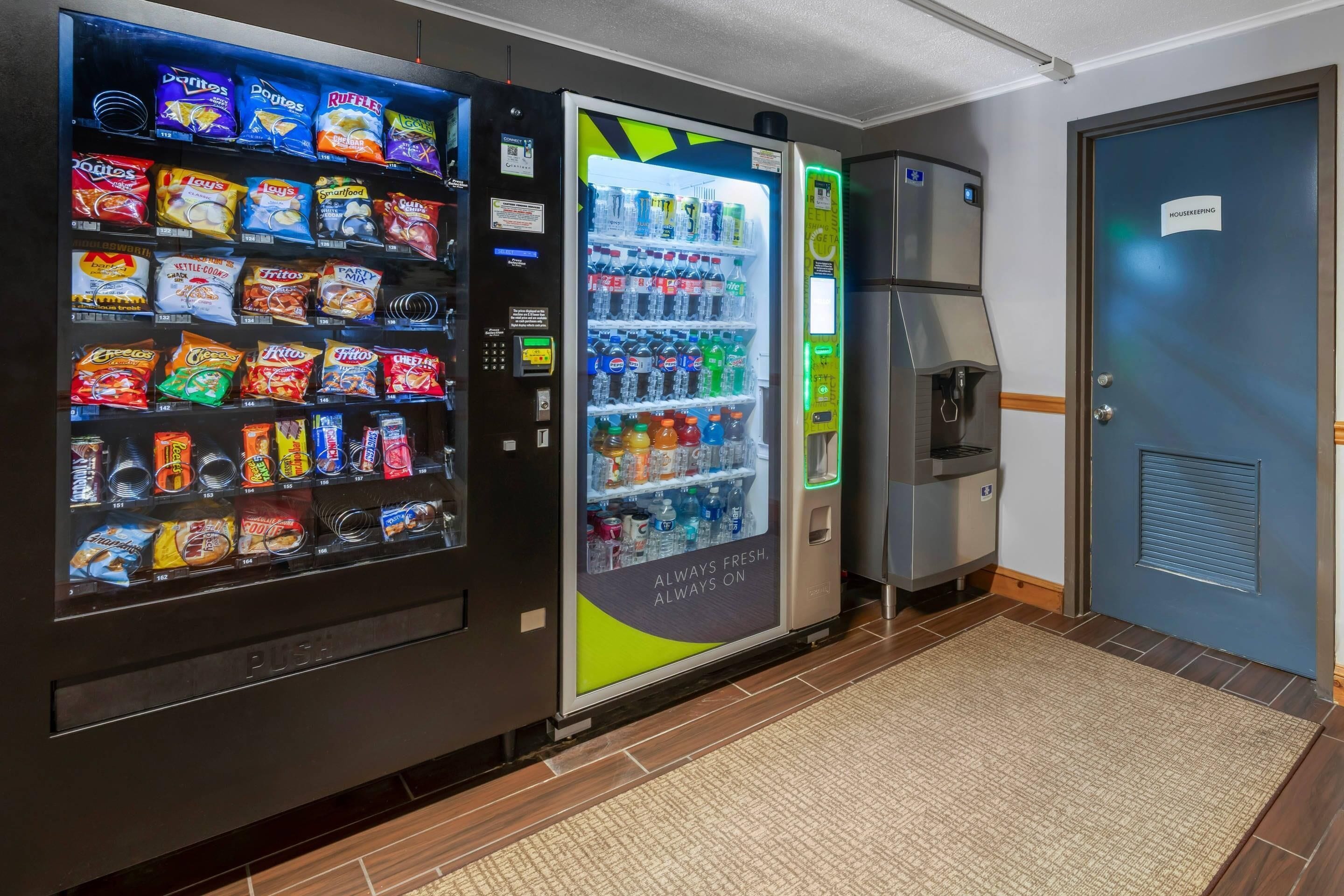 A vending machine area with snacks and drinks, a coffee machine, and a housekeeping sign.