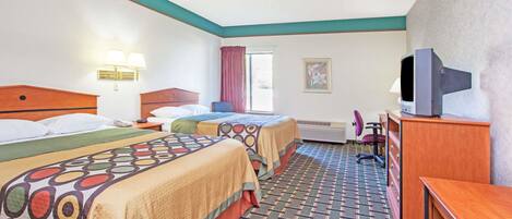 A hotel room with two beds, a desk, a television, and a window with curtains.