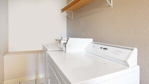 Une buanderie équipée de machines à laver et de sèche-linge superposés.