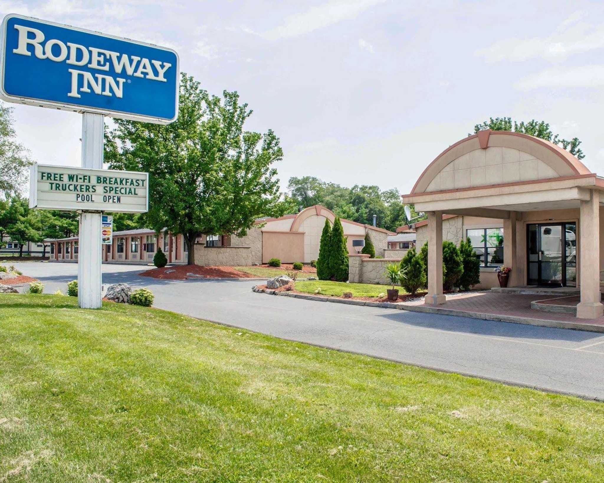 Un hôtel Rodeway Inn avec un panneau indiquant que le Wi-Fi et le petit-déjeuner sont gratuits, qu'il propose des offres spéciales pour les camionneurs et qu'il dispose d'une piscine.
