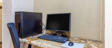 A computer desk with a desktop computer, keyboard, and mouse.