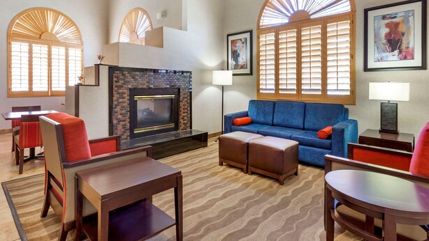 A hotel lobby with a fireplace, seating area, and artwork on the walls. - Comfort Inn Payson (Payson)