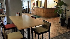 A restaurant with a wooden counter, a large potted plant, and a tiled floor. - Quality Inn Ozark-Springfield South (Ozark)