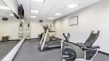 A gym with treadmills, a stationary bike, and a weight bench.