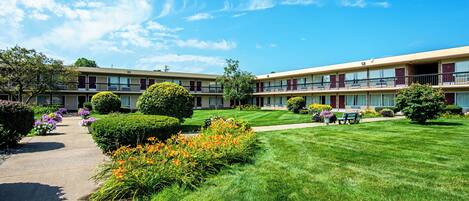 A two-story motel with a well-maintained lawn and flower beds.