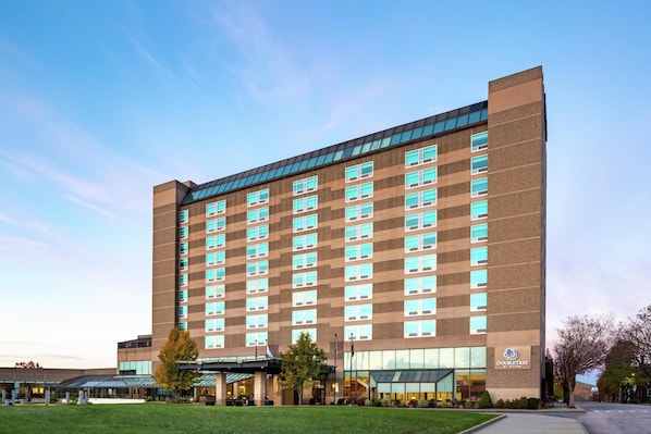 A multi-story hotel with a modern design, featuring a large glass facade, a flat roof, and a prominent entrance with a covered walkway.