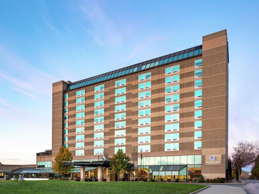 A multi-story hotel with a modern design, featuring a large glass facade, a flat roof, and a prominent entrance with a covered walkway.