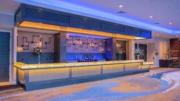 Ein Empfangsbereich mit moderner Bar, Wand mit Muster und Teppichboden.
