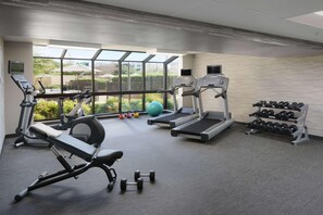 A gym with treadmills, an elliptical, a bench, dumbbells, and a kettlebell. - Courtyard by Marriott Dallas North (Dallas)