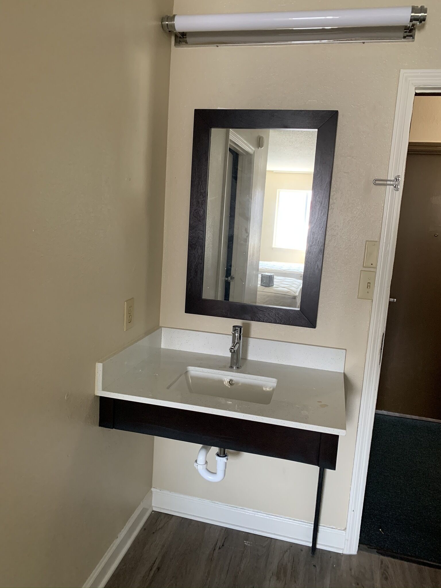 A bathroom with a white sink, a mirror, and a towel rack.