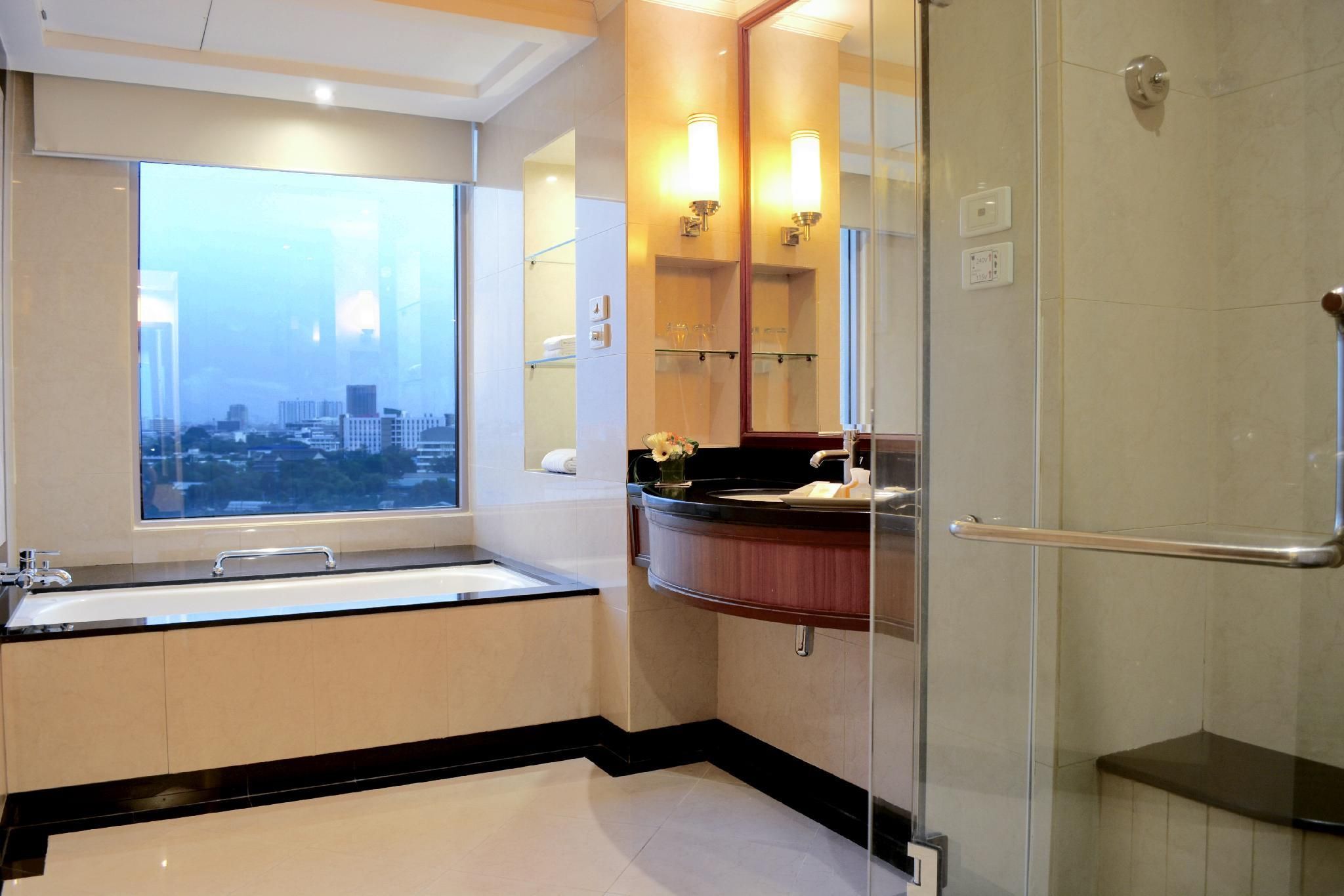 A modern bathroom with a large window, a glass shower enclosure, and a vanity with a mirror.
