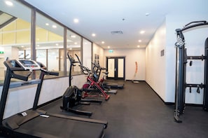 A gym with treadmills, stationary bikes, and a weight machine. - Sandman Signature Calgary Downtown Hotel (Calgary)