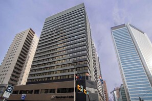 A tall hotel building with multiple floors, a visible hotel name, and a parking sign. - Sandman Signature Calgary Downtown Hotel (Calgary)