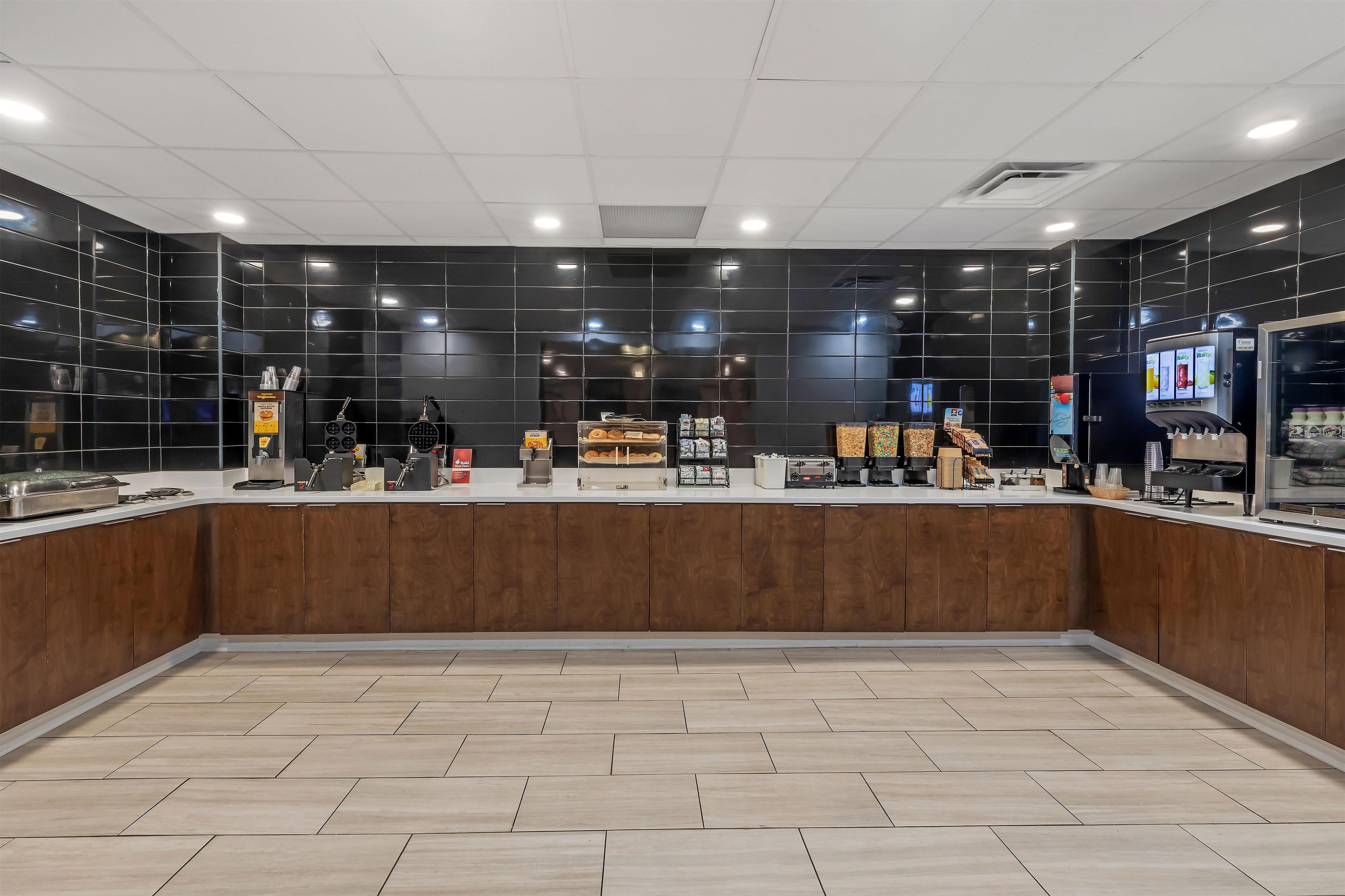 A modern cafe interior with a counter, seating area, and various food and drink dispensers.