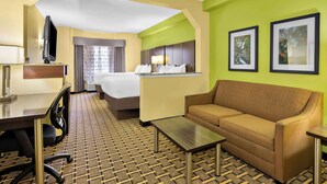 A hotel room with a bed, a sofa, a desk, a chair, a TV, and framed pictures on the wall. - Best Western Knoxville Suites - Downtown (Knoxville)