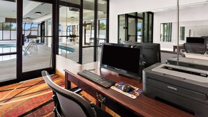 A hotel room with a desk, computer, printer, and a view of the pool area. - Best Western Knoxville Suites - Downtown (Knoxville)
