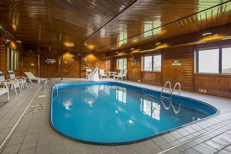 Una piscina techada, sillones reclinables de piscina