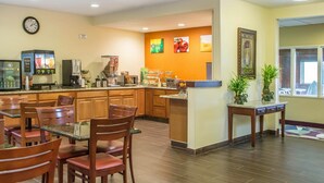 A hotel lobby with a coffee station, seating area, and a clock on the wall. - Quality Inn & Suites Bloomington I-55 and I-74 (Bloomington)