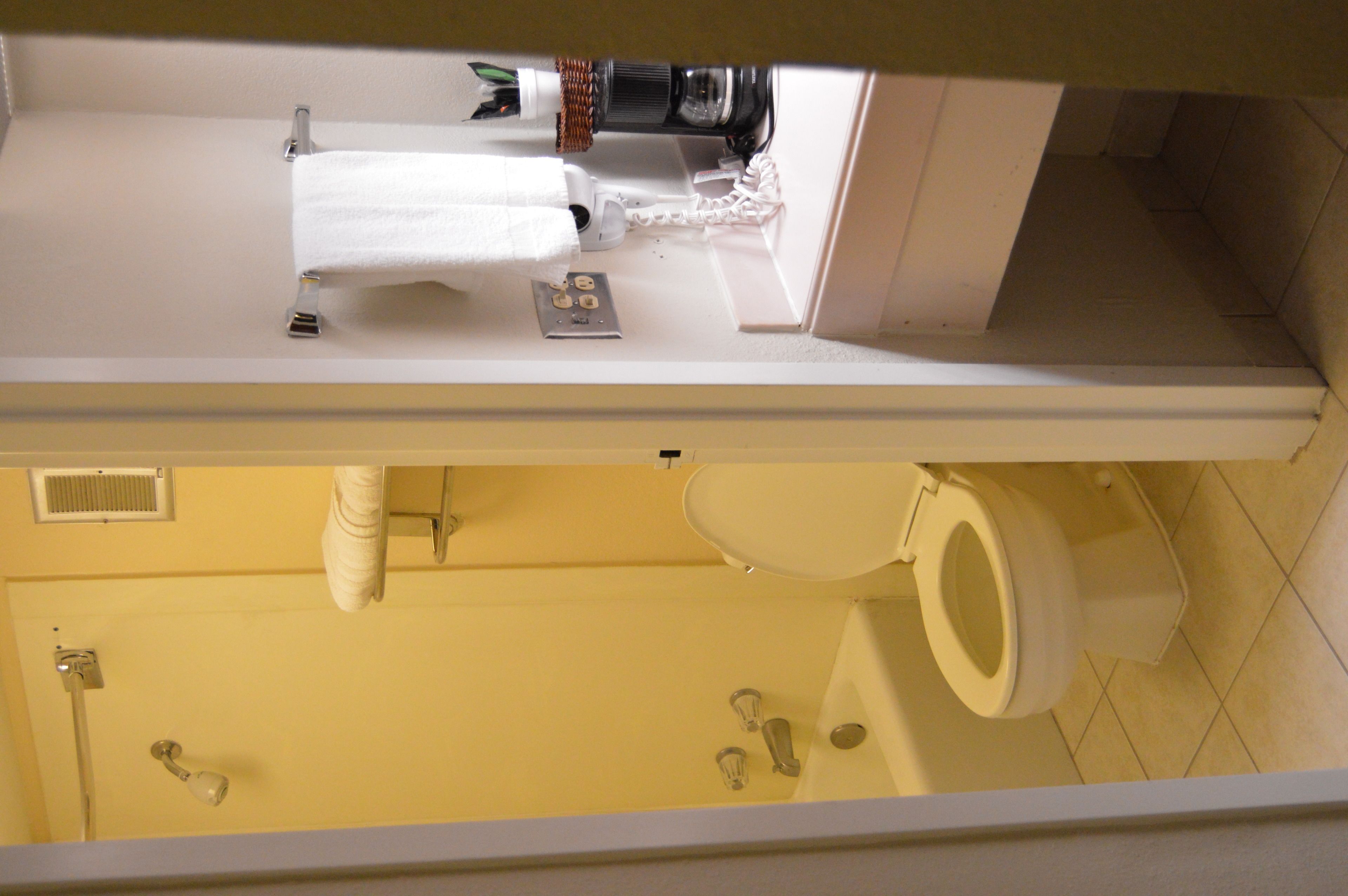 A bathroom with a white sink, a white toilet, and a shower area.