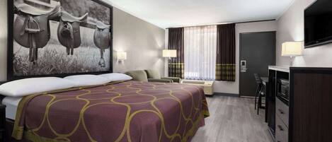 A hotel room with a large bed, a desk, a TV, and a painting of horses.