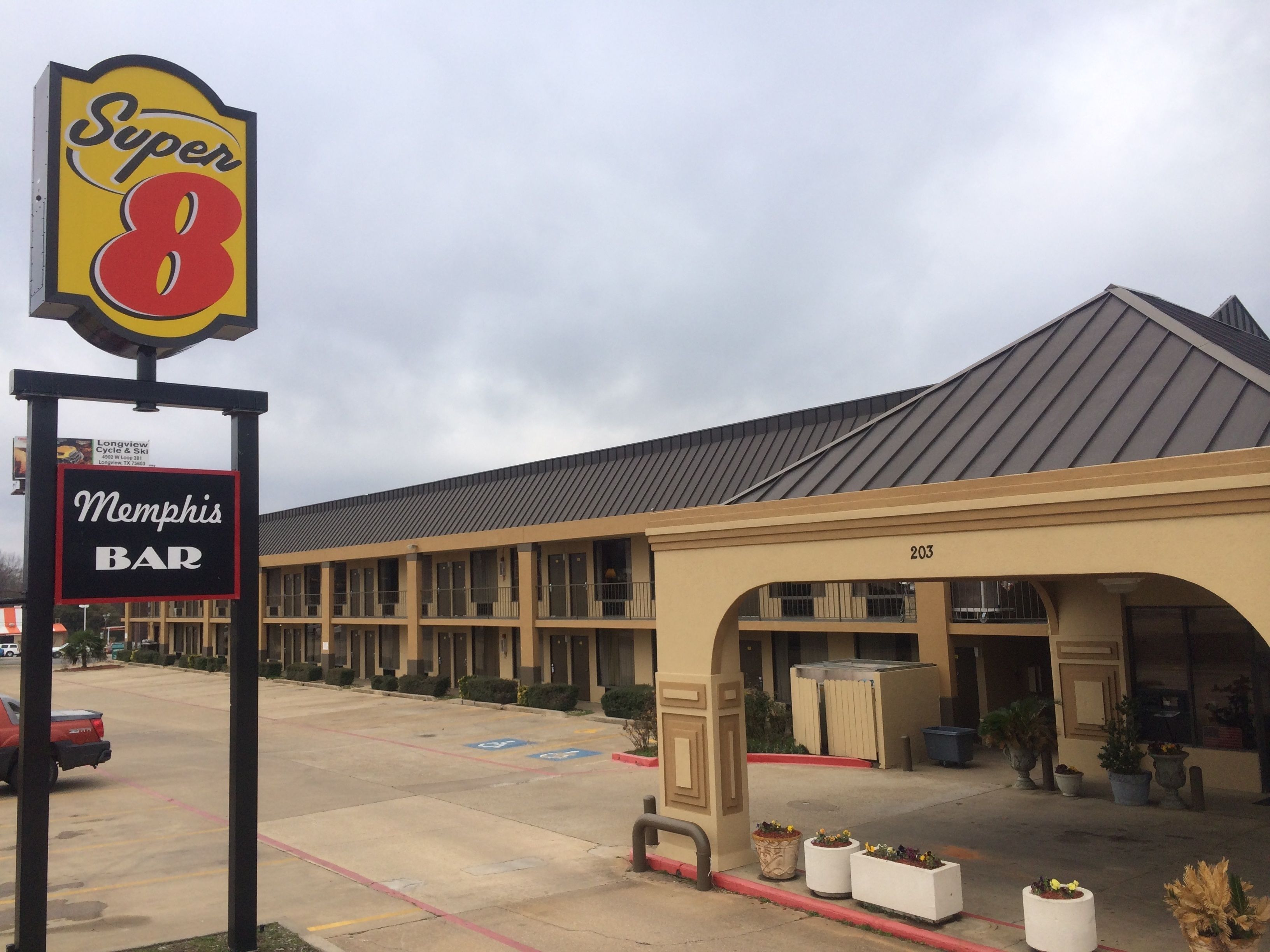 A motel with a Super 8 sign and a Memphis Bar sign.