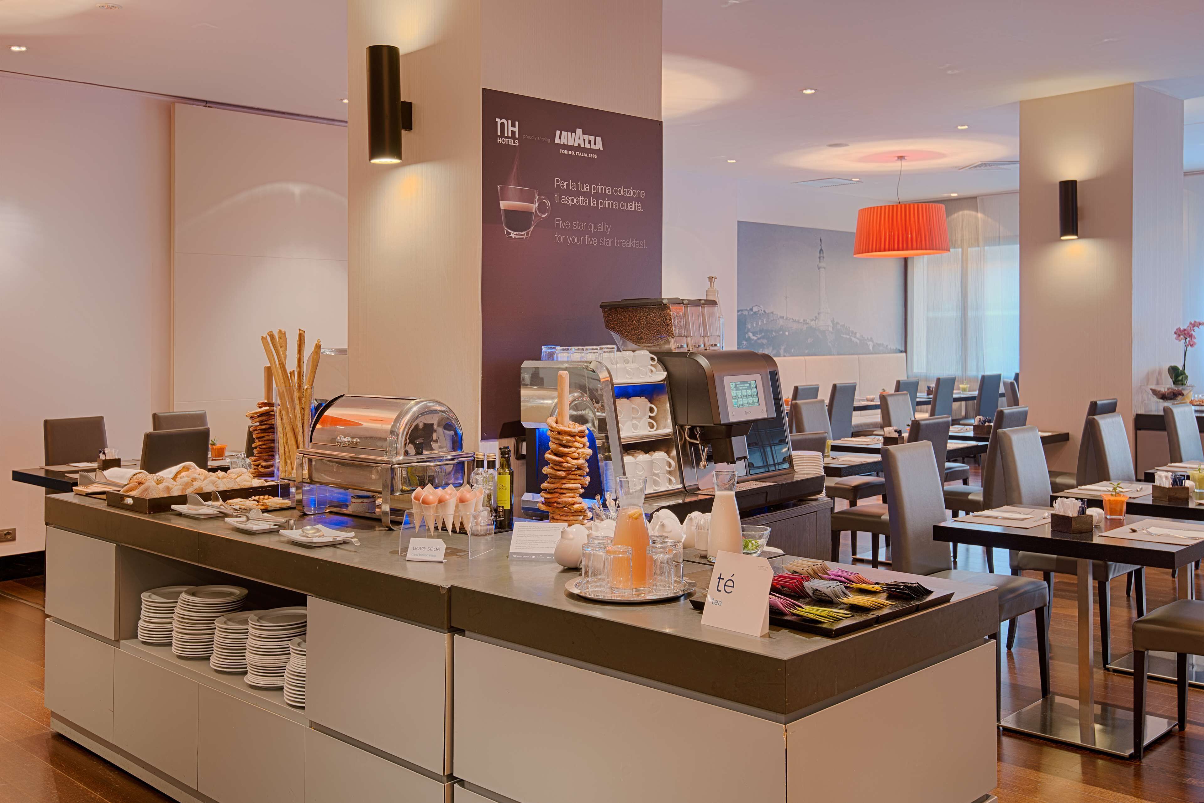 A hotel breakfast area with a buffet setup, including various food items and a coffee station.