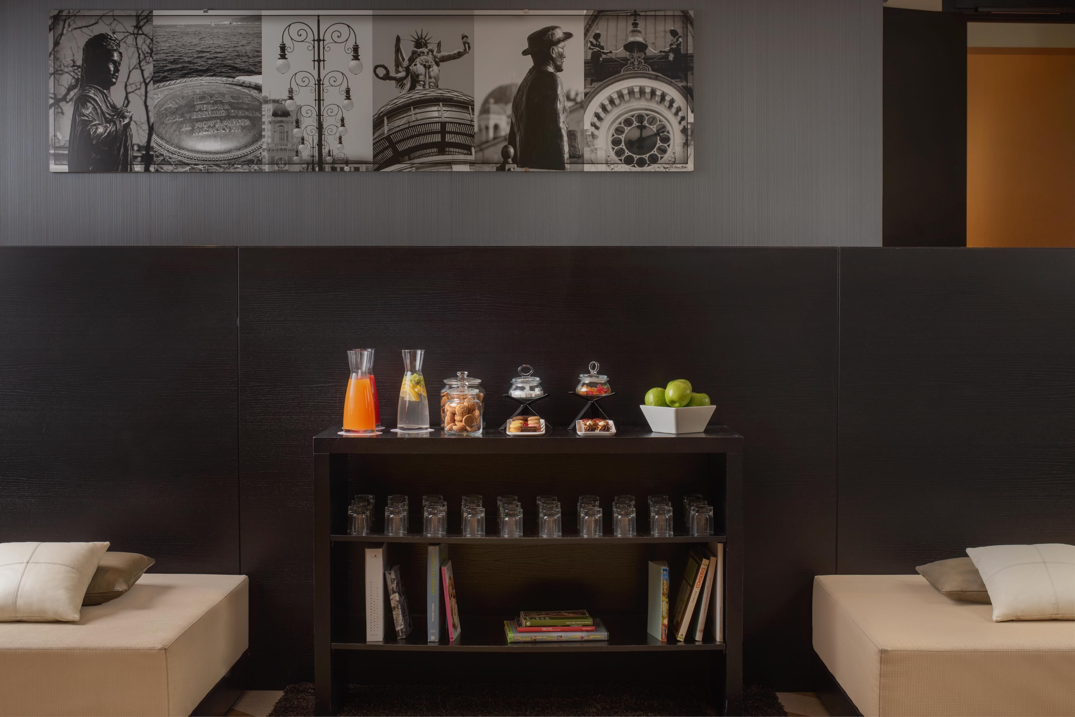 A modern living room with a dark wood bookshelf, two beige sofas, and a wall-mounted art piece.