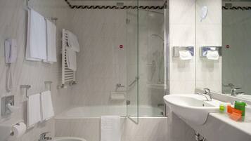 Ein modernes Badezimmer mit Badewanne, Dusche, Waschbecken und Toilette.