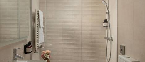 A modern bathroom with a shower, a sink, and a mirror.