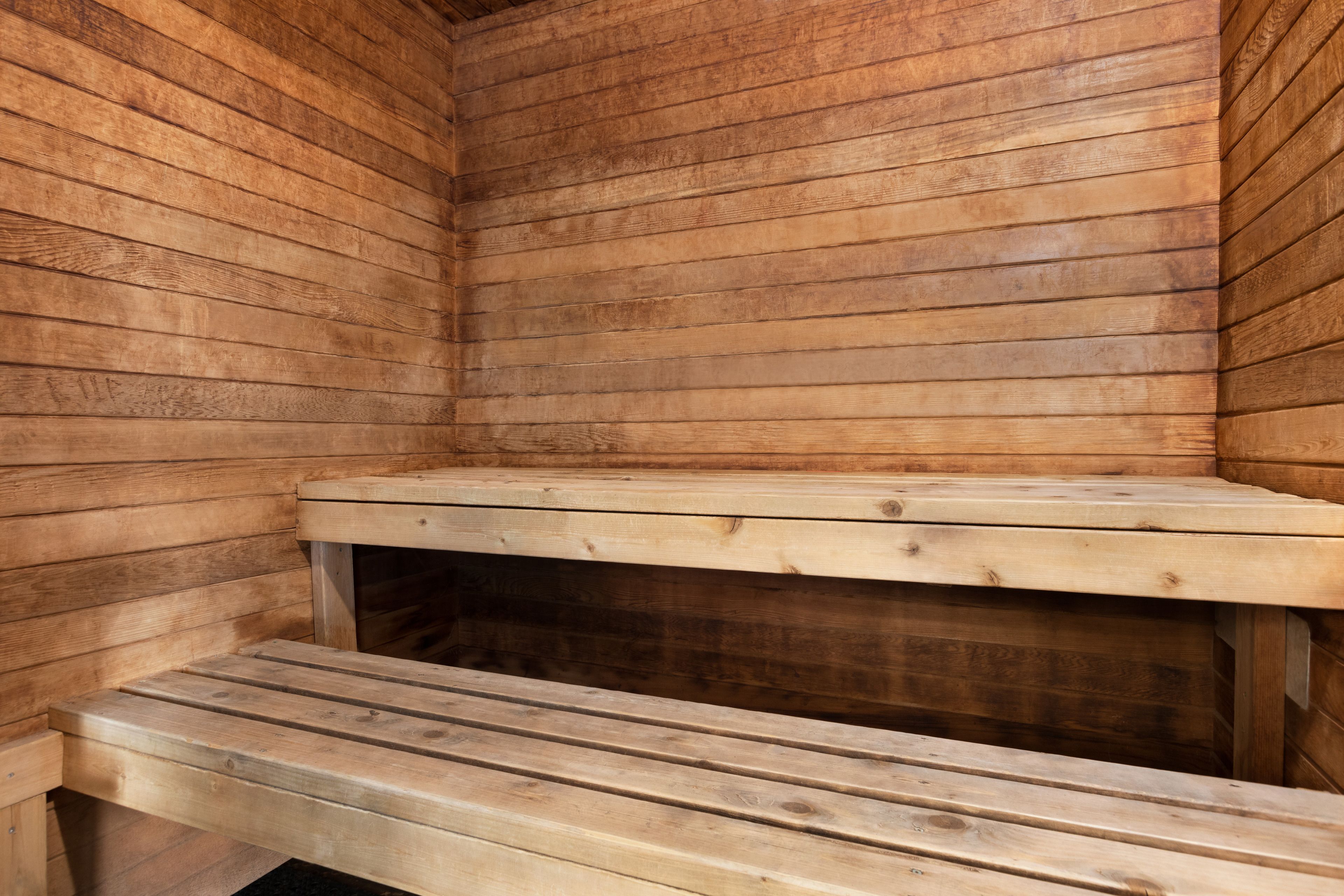 A wooden sauna with benches and a bench seat.