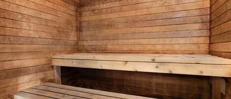 Een houten sauna met banken en een lange zitting.