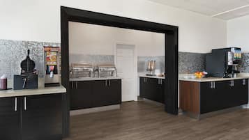 A modern kitchen with dark cabinets, a tiled backsplash, and a central island.