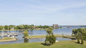 Un port de plaisance avec des bateaux, une zone herbeuse et des bâtiments en arrière-plan.