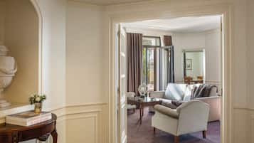 Una habitación con sofá, una mesa y una silla. Hay una puerta que conduce a otra habitación.
