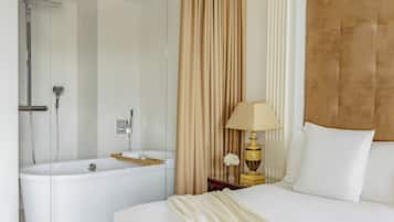 Habitación de hotel moderna con una cama grande, una bañera, un espejo, una lámpara y una cortina.