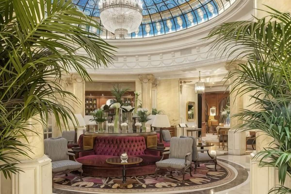 Un hall d’entrée luxueux, doté d’un espace salon central, d’un magnifique lustre et d’un plafond en forme de coupole.