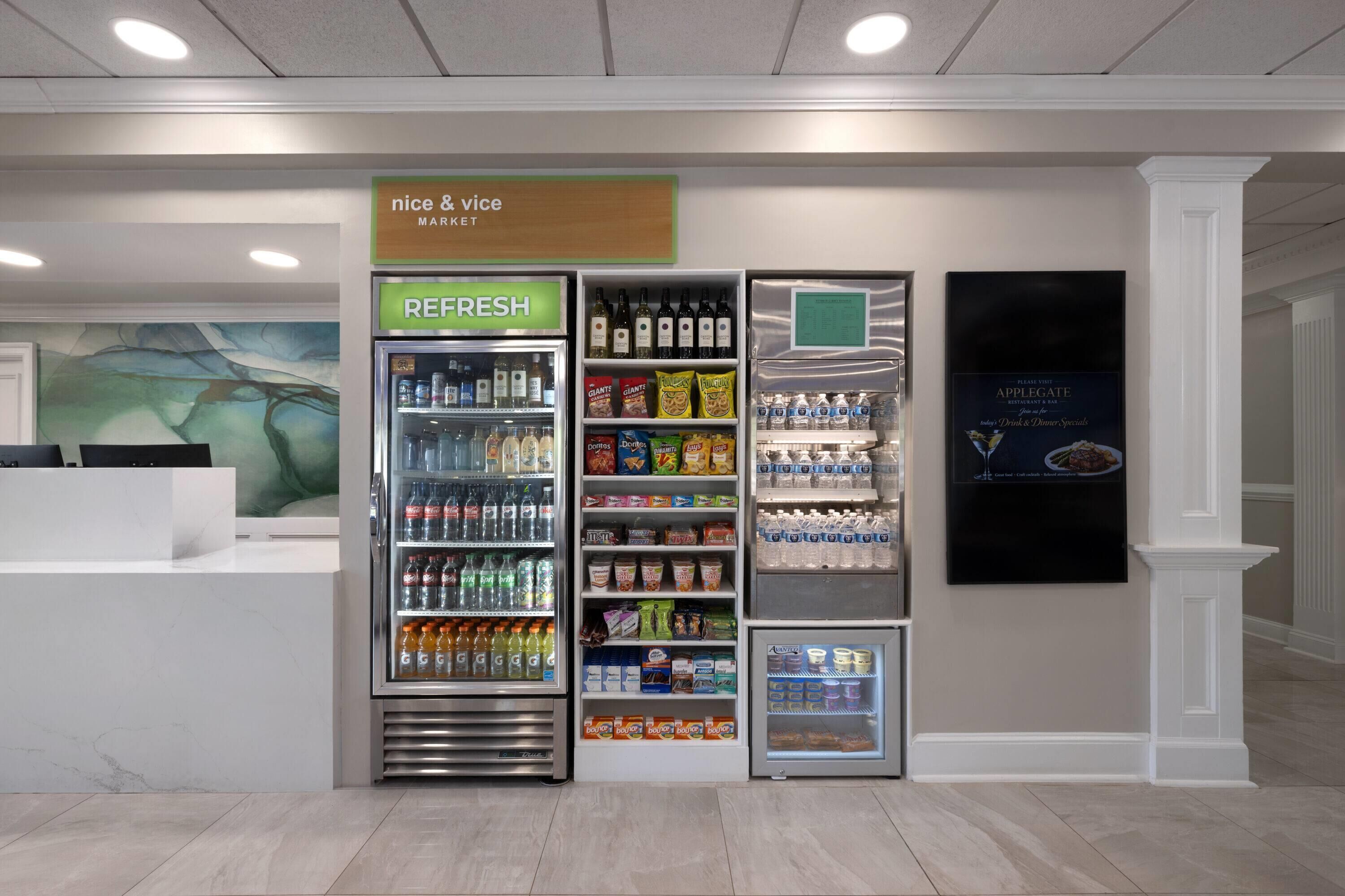 A refreshment area with a 'nice & vice market' sign, a 'REFRESH' sign above a beverage cooler, and a 'please visit APPLEGATE' sign.